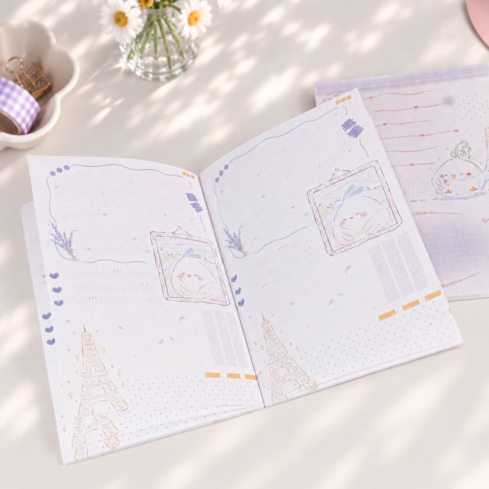 Little Chirp A6 notepad open pages with soft purple stationery illustrations