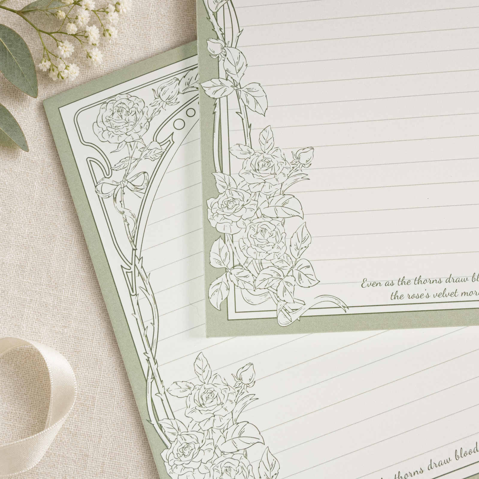 Gros plan du bloc-notes B5 Thorn Rose avec bordure de roses vert sauge et pages lignées